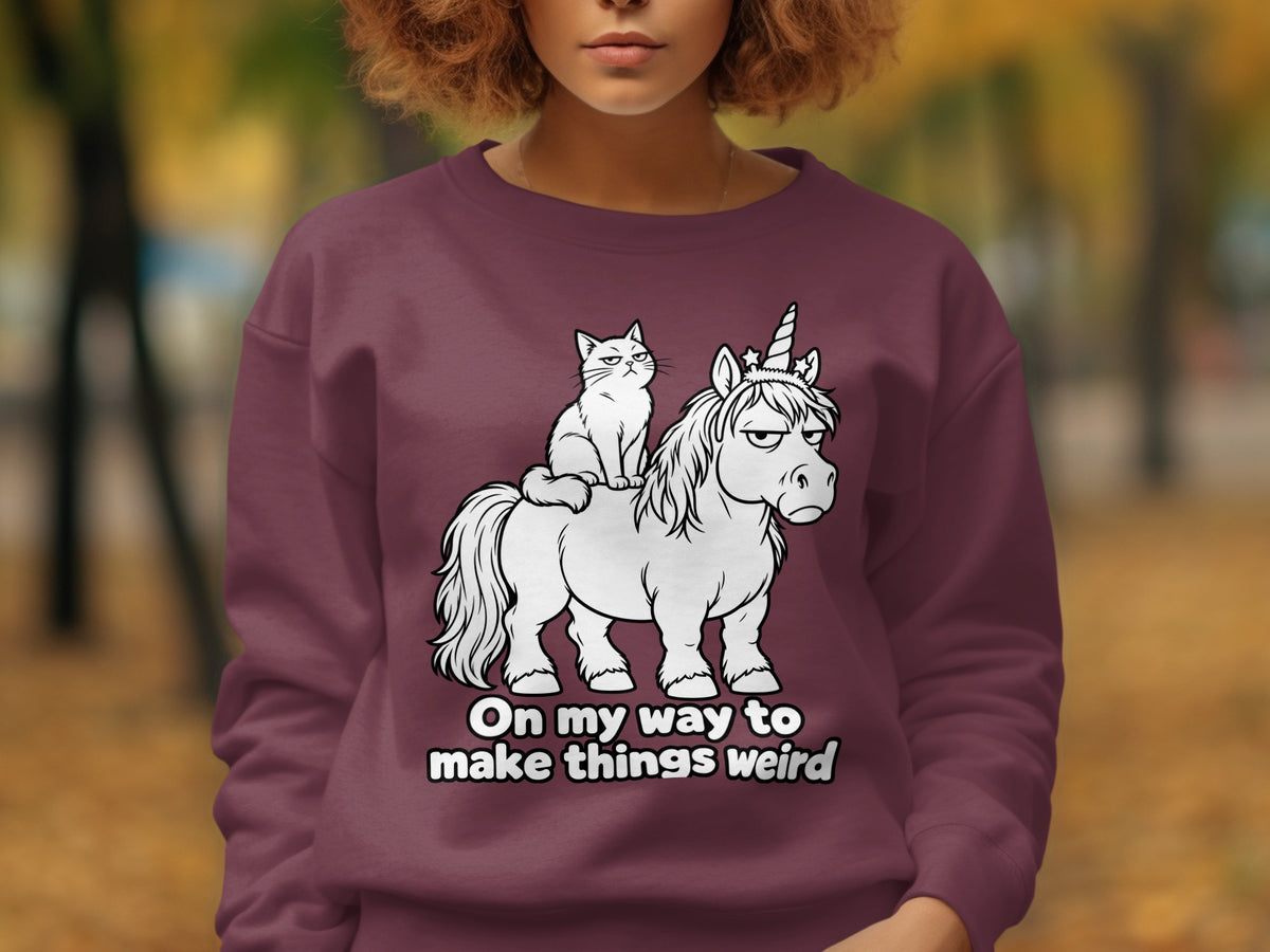 Cat riding a grumpy unicorn with text "On my way to make things weird".