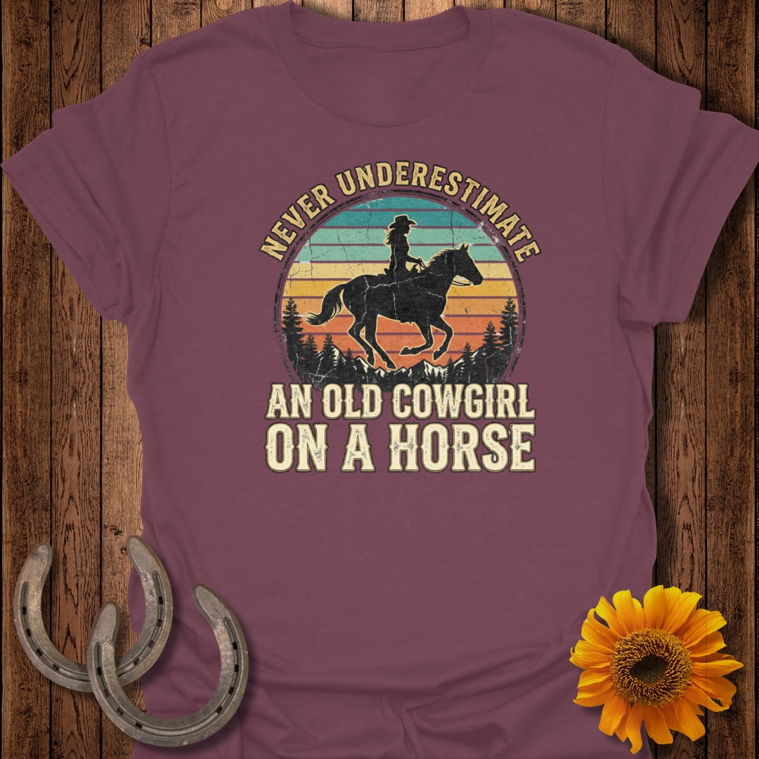 T-shirt with "Never Underestimate An Old Cowgirl On A Horse" text and horse graphic.