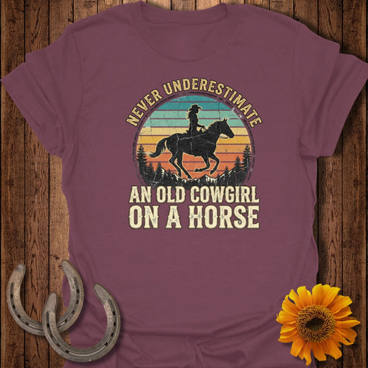 T-shirt with "Never Underestimate An Old Cowgirl On A Horse" text and horse graphic.