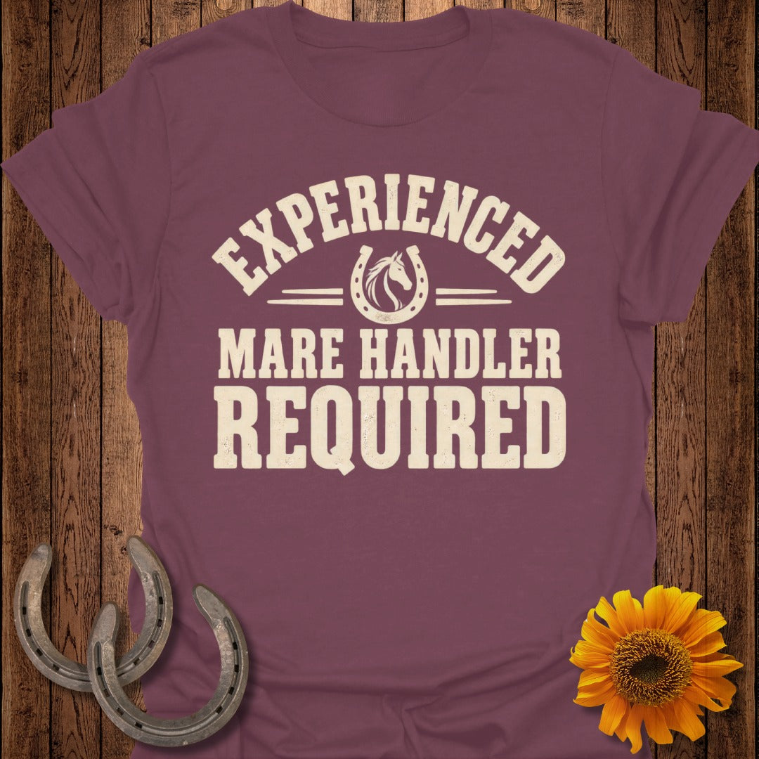 Maroon t-shirt with text "EXPERIENCED MARE HANDLER REQUIRED" and horseshoe graphic.