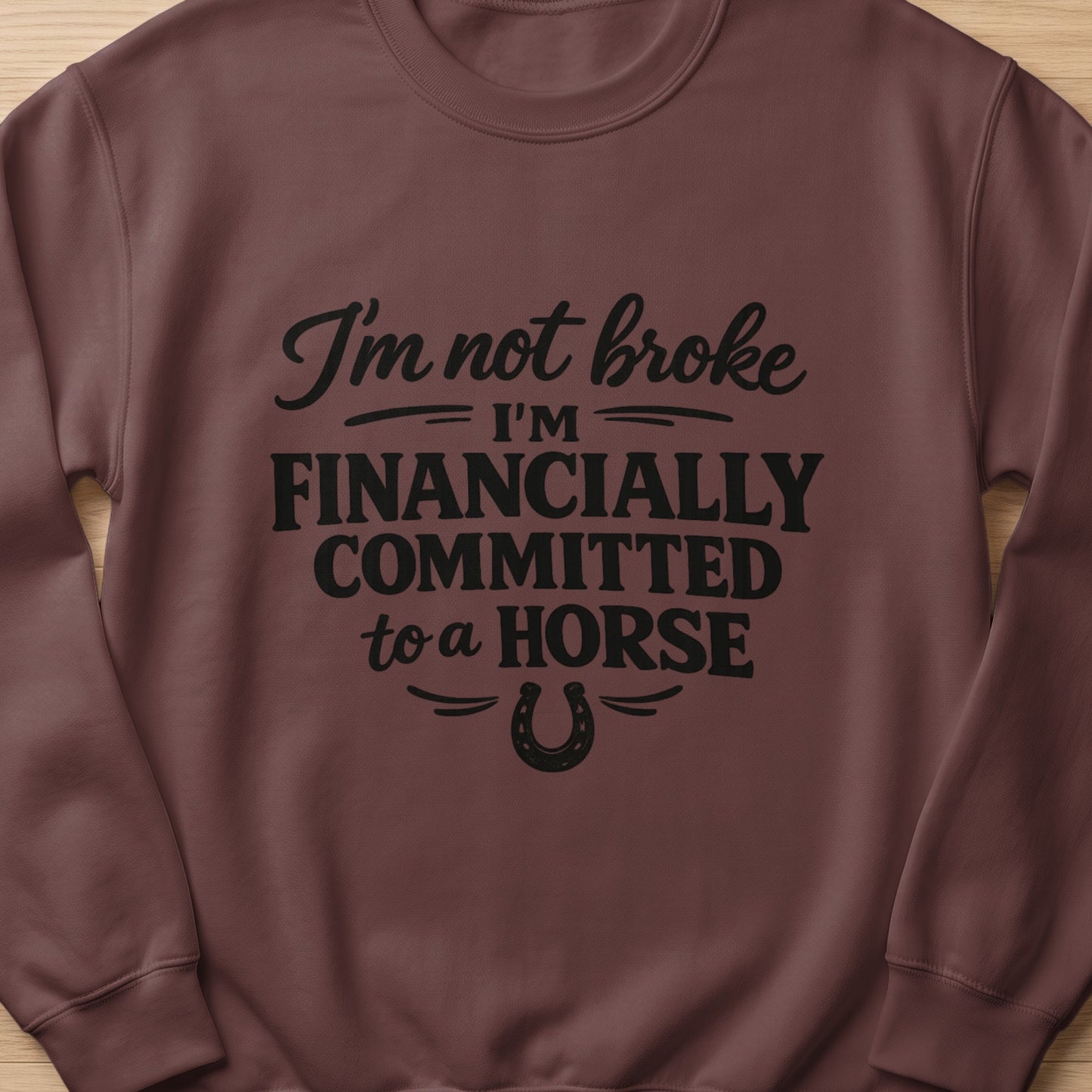 Brown sweatshirt with text "I'm not broke, I'm financially committed to a horse."