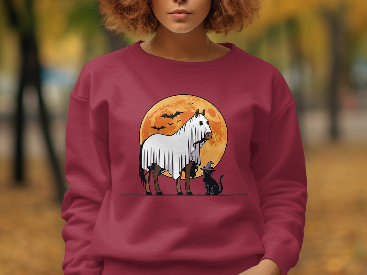 Horse in ghost costume with black cat against orange moon and bats.