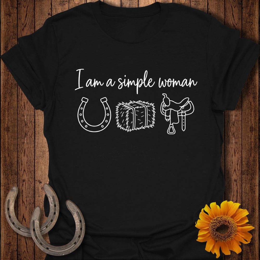 A black t-shirt printed with the text I am a simple woman, a horseshoe, hay bale, and saddle.