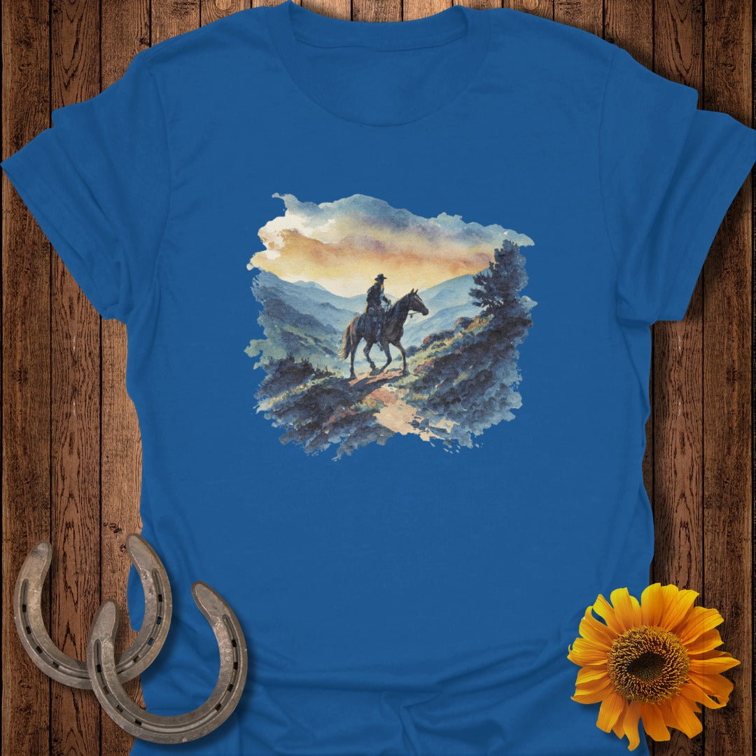 Watercolor art of a cowboy on horseback with mountains and a sunset.