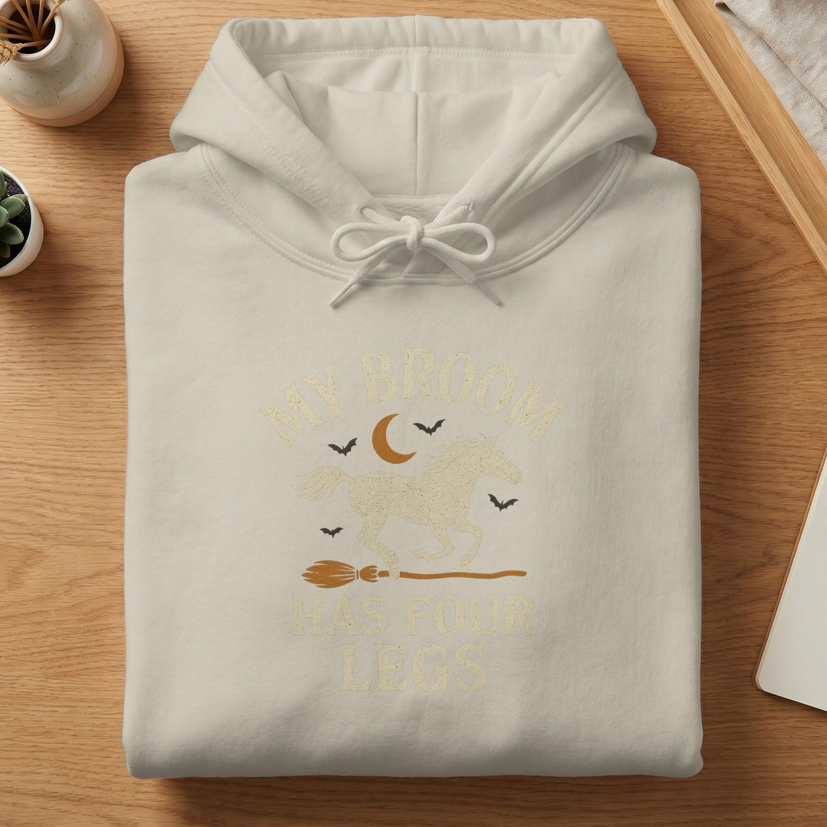 Light beige hoodie with "My Broom Has Four Legs" text and horse graphic.