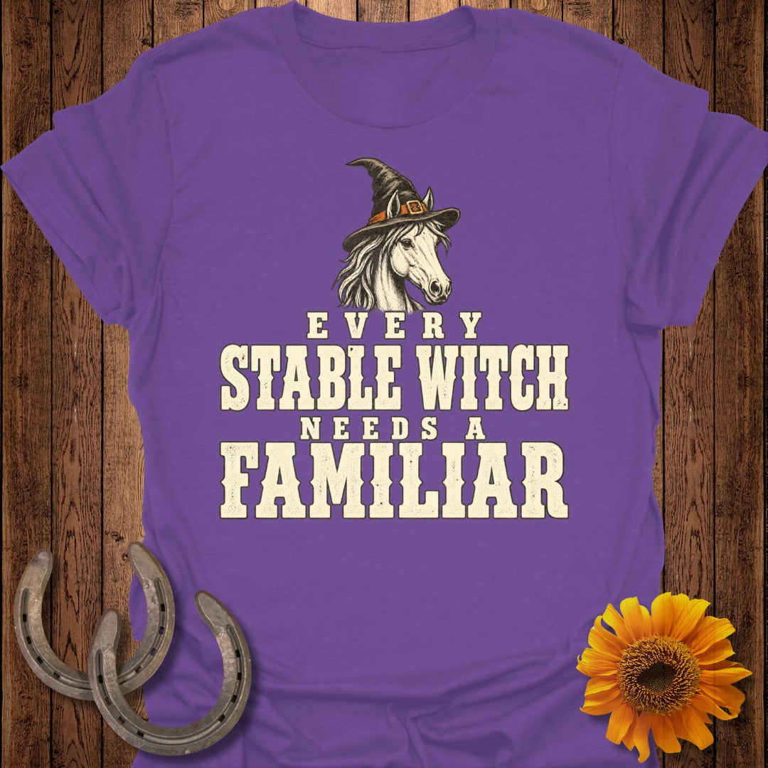 Purple t-shirt with a horse in a witch hat and text "Every Stable Witch Needs a Familiar."