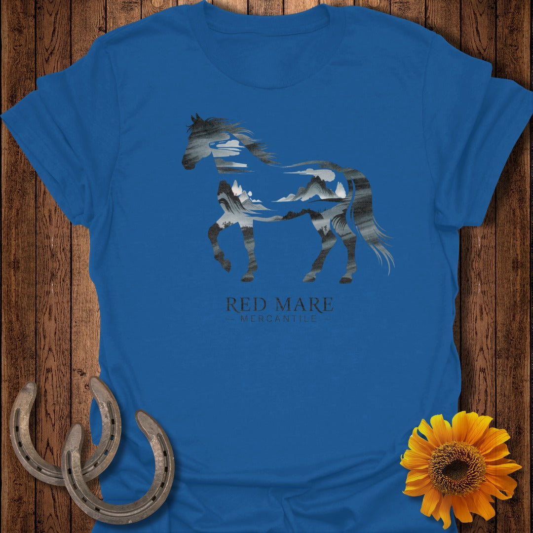 Blue t-shirt with a horse silhouette filled with a mountain landscape.