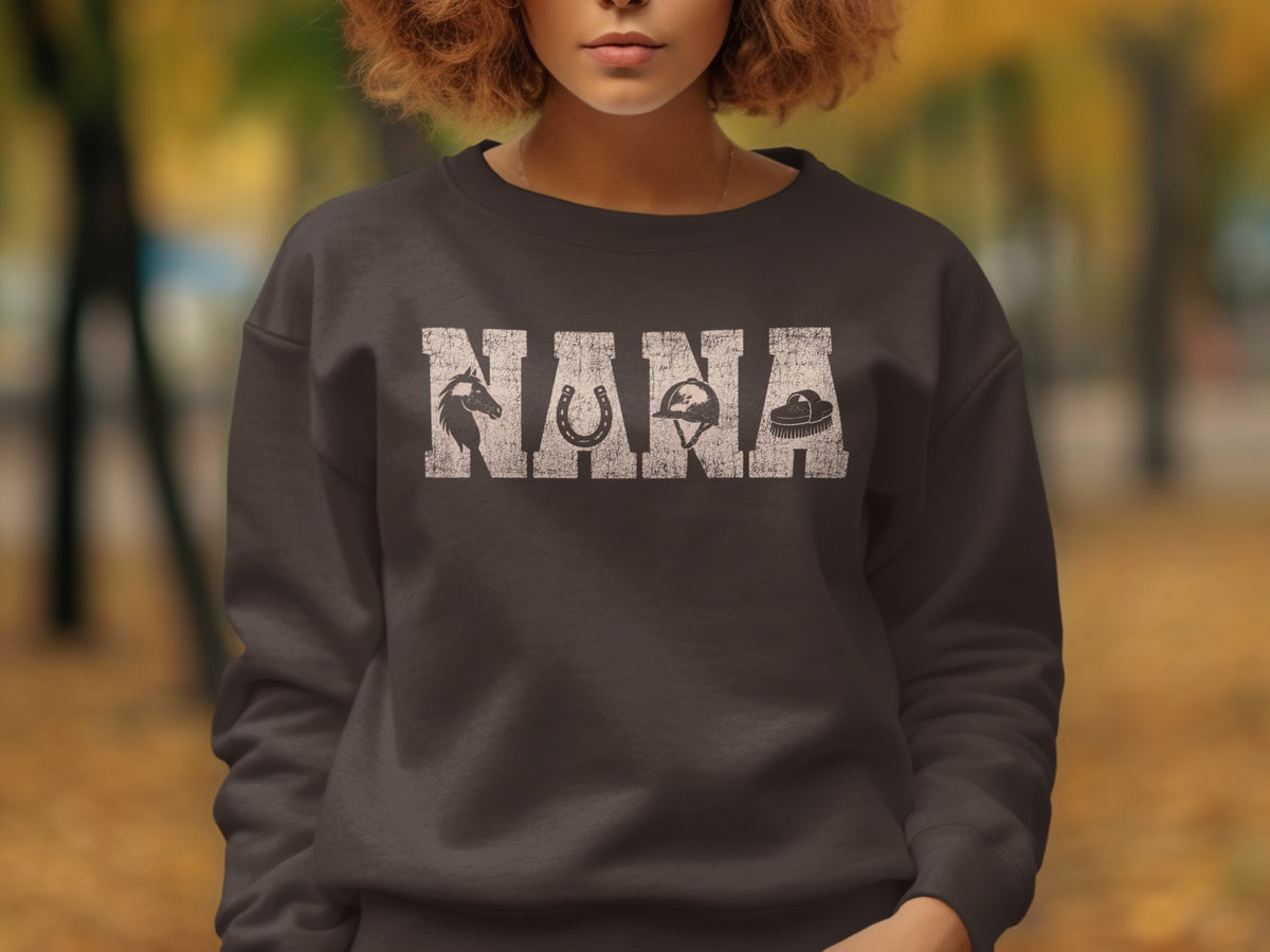 Dark grey sweatshirt with "NANA" text and horse, horseshoe, helmet, and brush graphics.