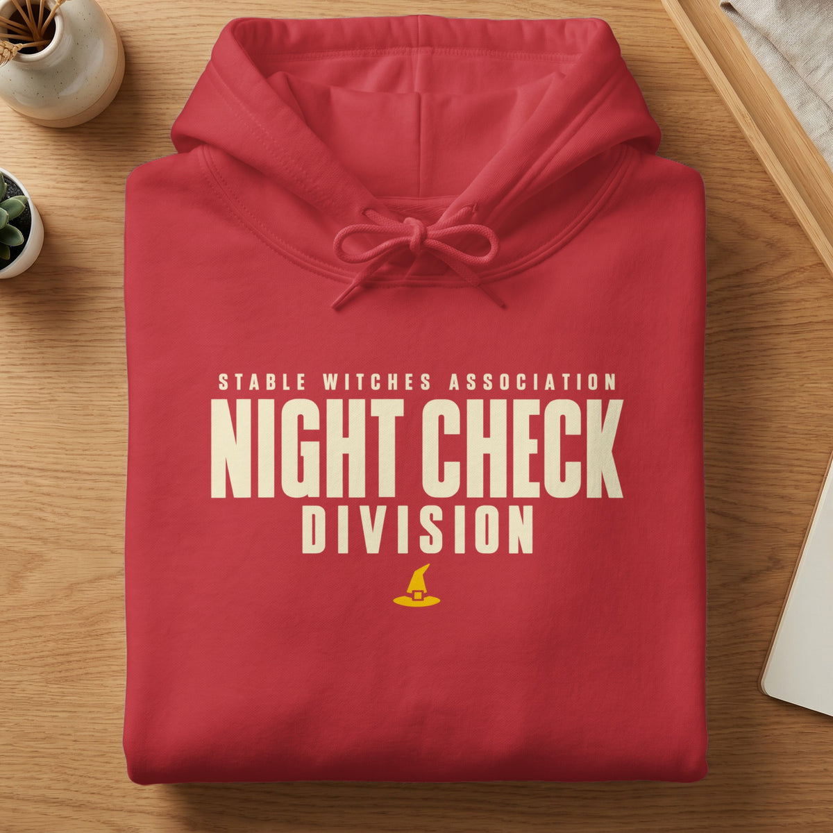 Red hoodie with "STABLE WITCHES ASSOCIATION NIGHT CHECK DIVISION" text and witch hat graphic.