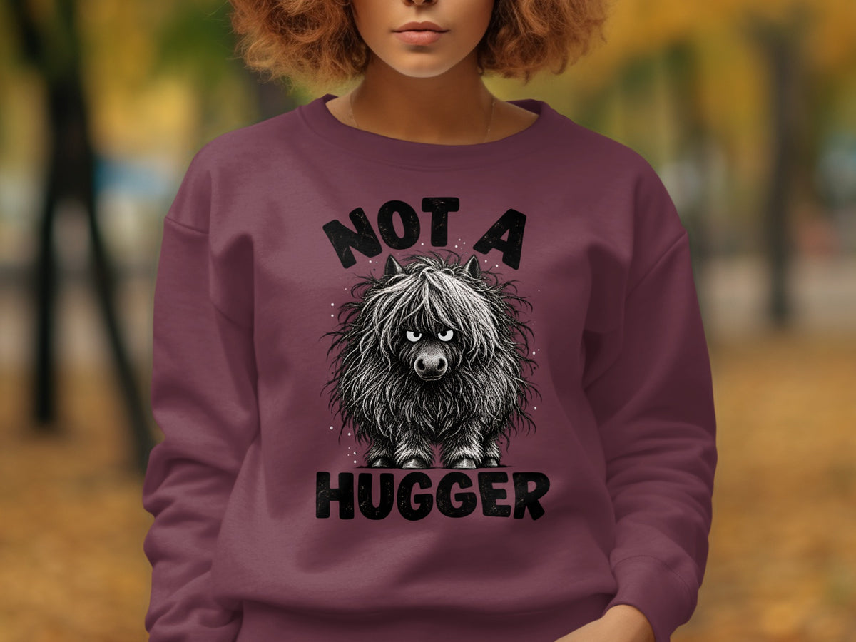 Maroon sweatshirt with a black graphic of a fluffy, grumpy Highland cow and text.