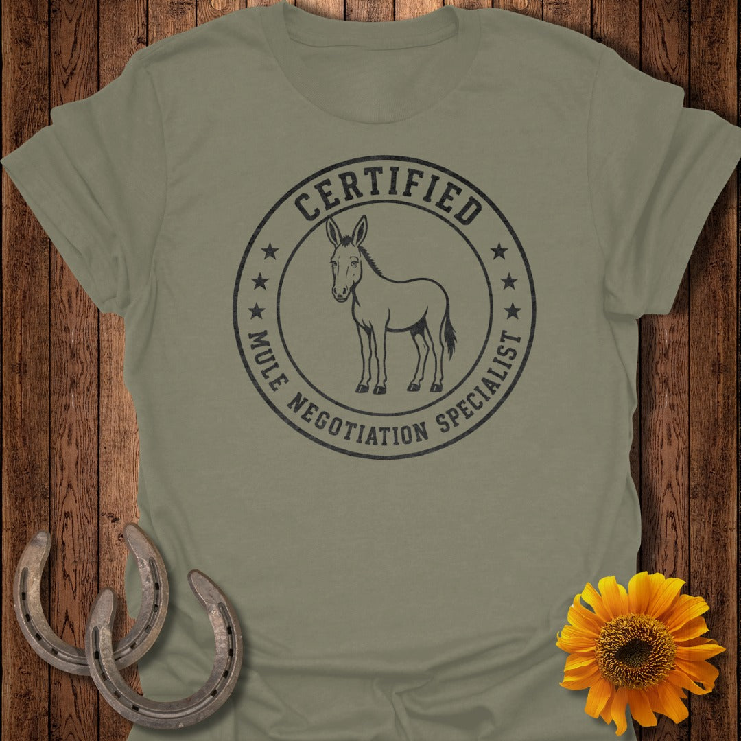 Olive t-shirt with circular graphic reading "CERTIFIED MULE NEGOTIATION SPECIALIST" and a mule.