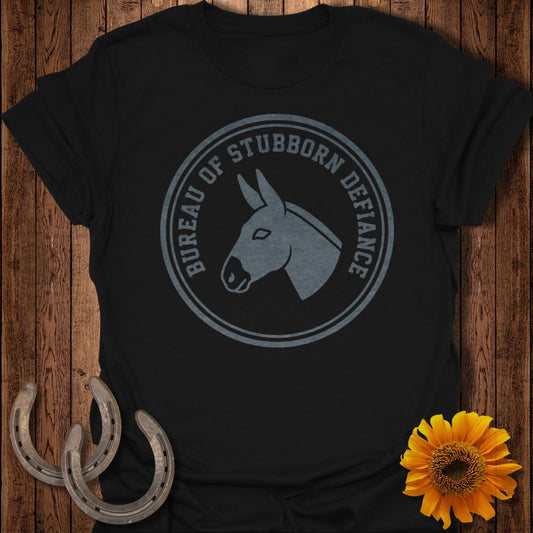 Black t-shirt with circular logo of a donkey head and "Bureau of Stubborn Defiance" text.