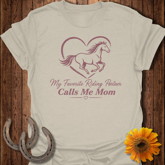 Light brown t-shirt with a horse inside a heart and "My Favorite Riding Partner Calls Me Mom" text.