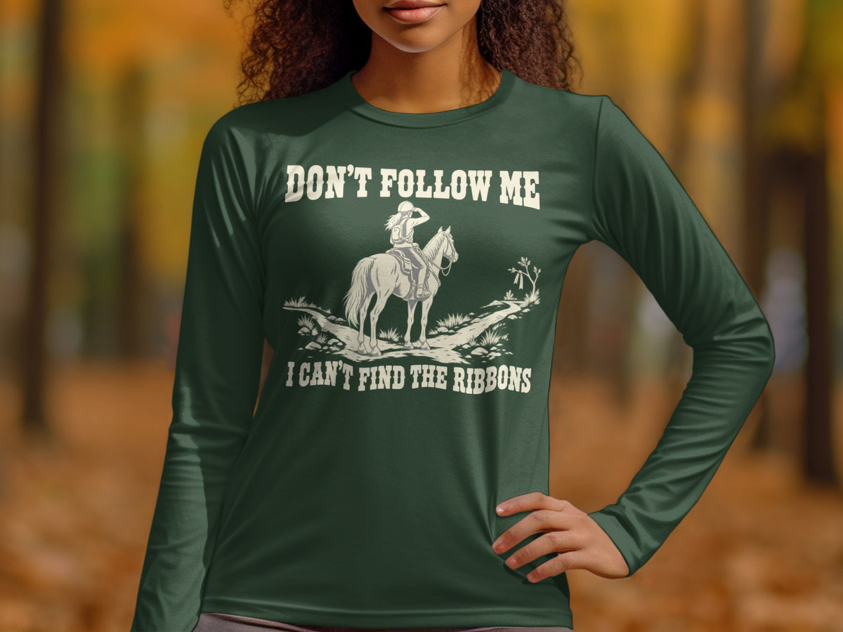 A woman wearing a dark green long-sleeve shirt with an equestrian graphic and humorous text.