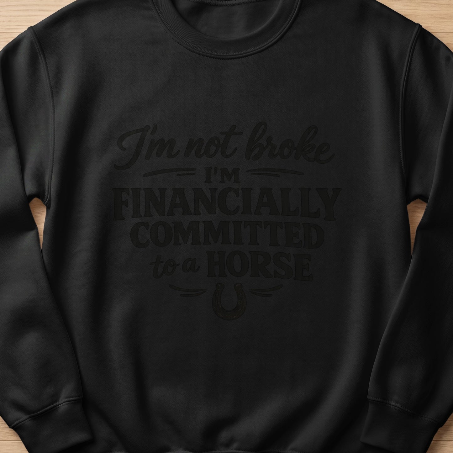 Black sweatshirt with text "I'm not broke, I'm financially committed to a horse."