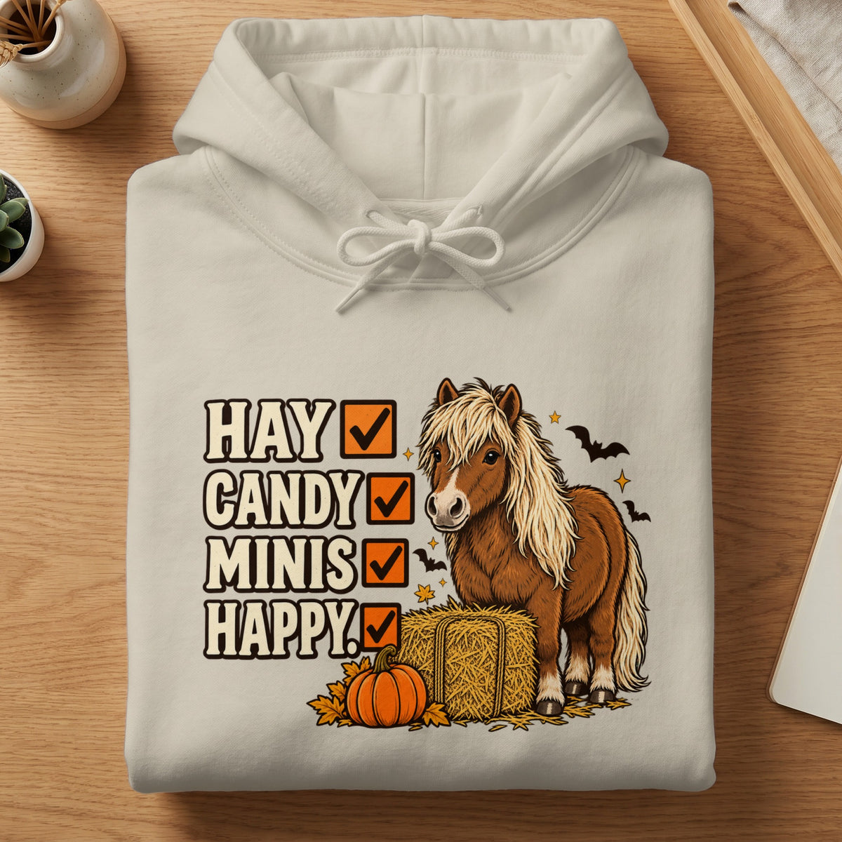 Cream hoodie with a graphic of a pony, hay bale, pumpkin, and Halloween bats.