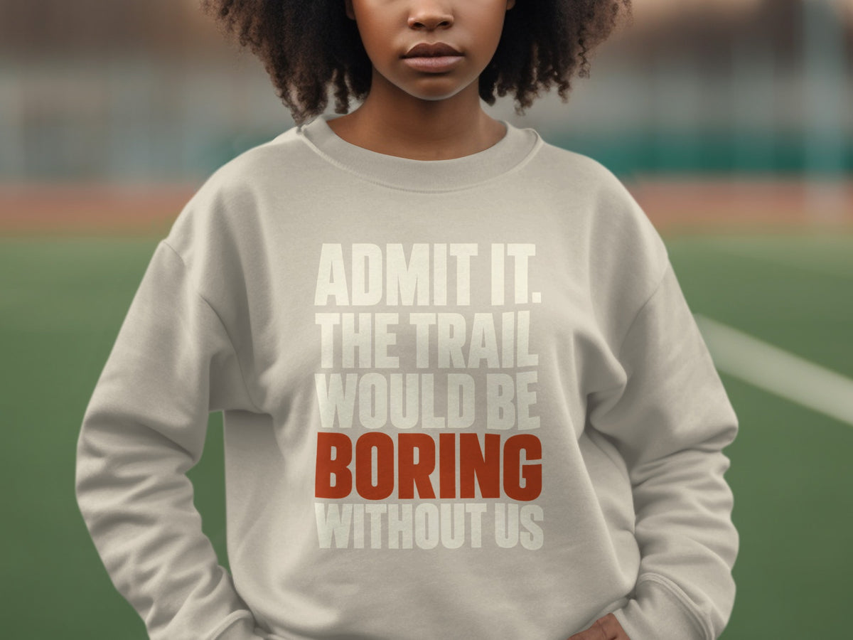 A person wearing a light gray sweatshirt with the text "ADMIT IT. THE TRAIL WOULD BE BORING WITHOUT US" printed across the chest.