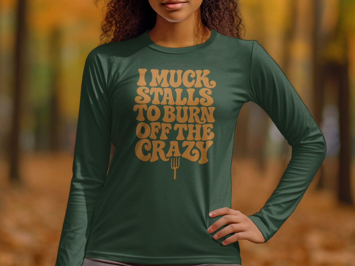 Green long-sleeve shirt with "I muck stalls to burn off the crazy" text and pitchfork graphic.