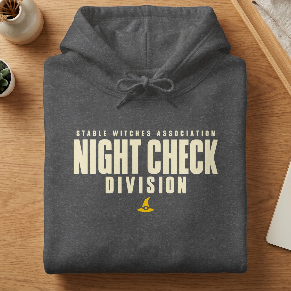 Dark grey hoodie with "Stable Witches Association Night Check Division" text and a witch hat.