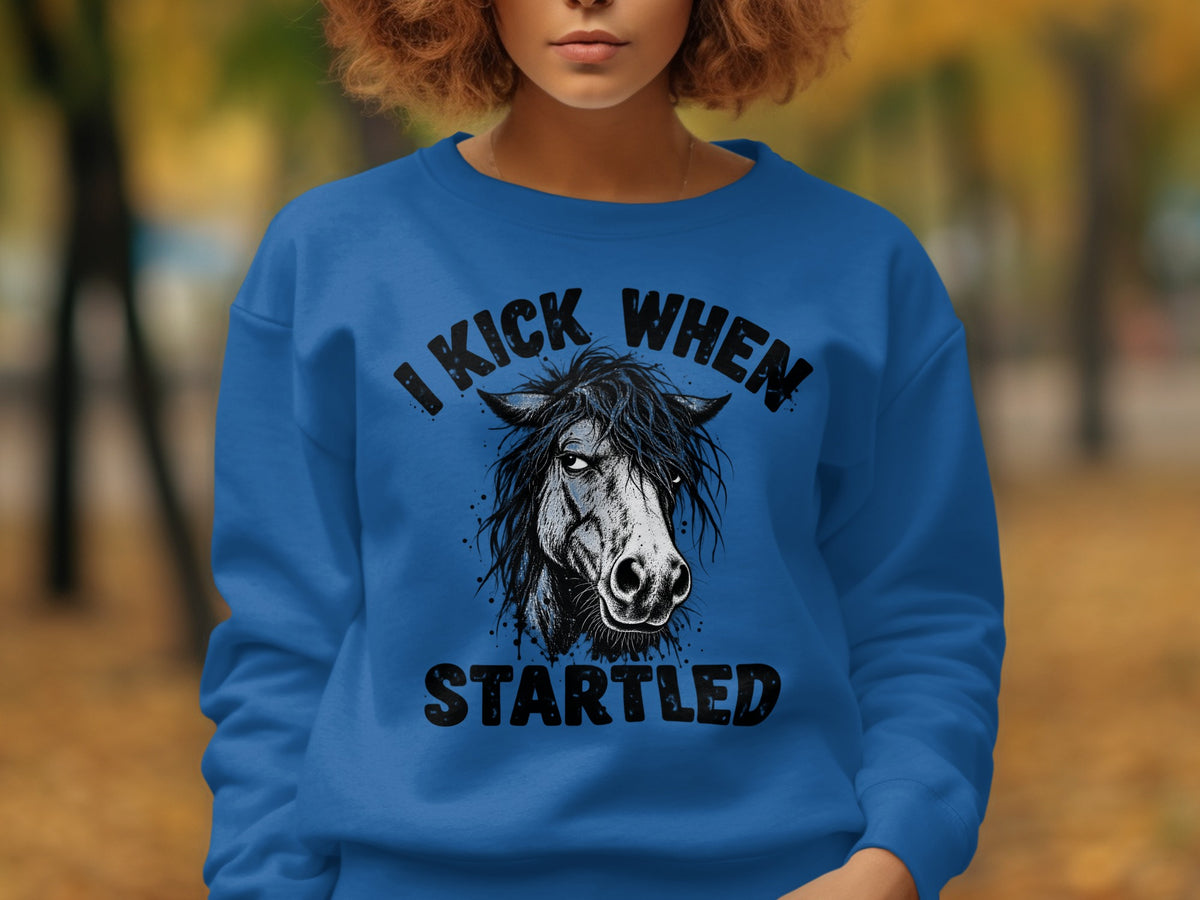 Blue sweatshirt with a horse graphic and text "I KICK WHEN STARTLED".