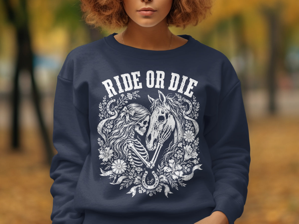 Navy sweatshirt with "RIDE OR DIE" text above skeleton, horse, and floral design.