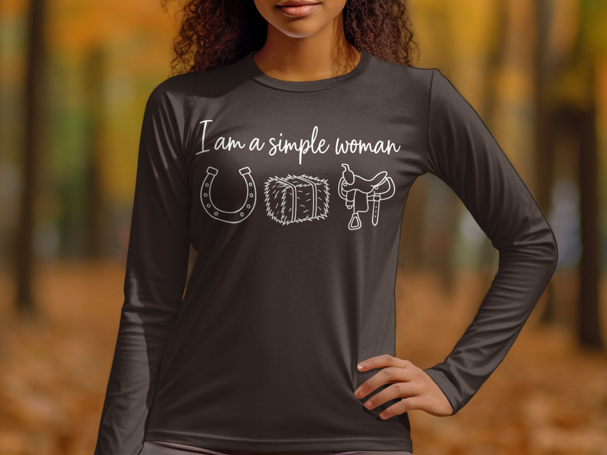 Dark long-sleeve shirt with white text "I am a simple woman" and horseshoe, hay, saddle graphic.