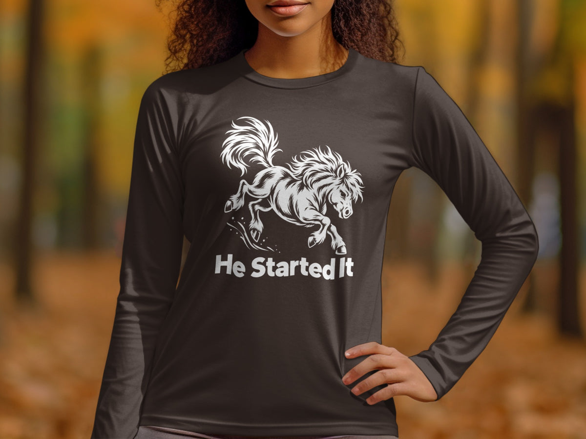A person wearing a dark grey long-sleeve shirt with a white graphic of a bucking horse and text that reads "He Started It".