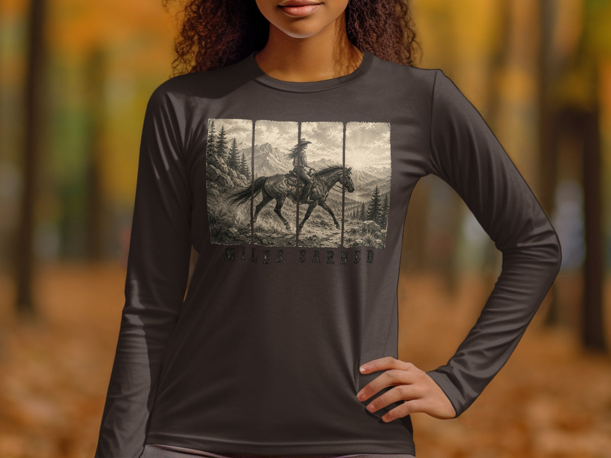 Long sleeve shirt with a sepia-toned graphic of a cowboy on horseback in mountains with "MILES EARNED" text.