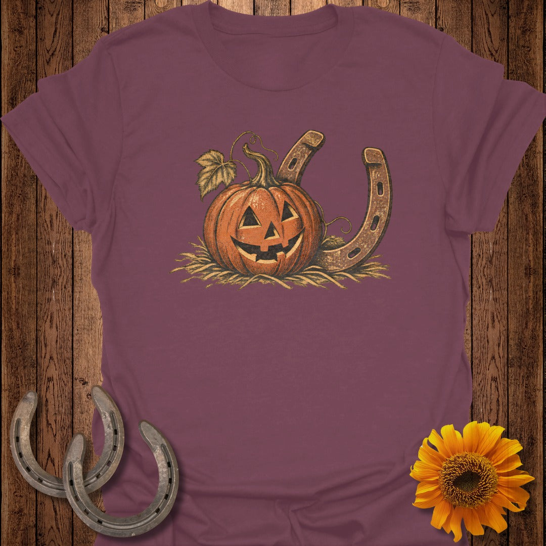 Jack-o-lantern and horseshoe graphic on a maroon t-shirt.