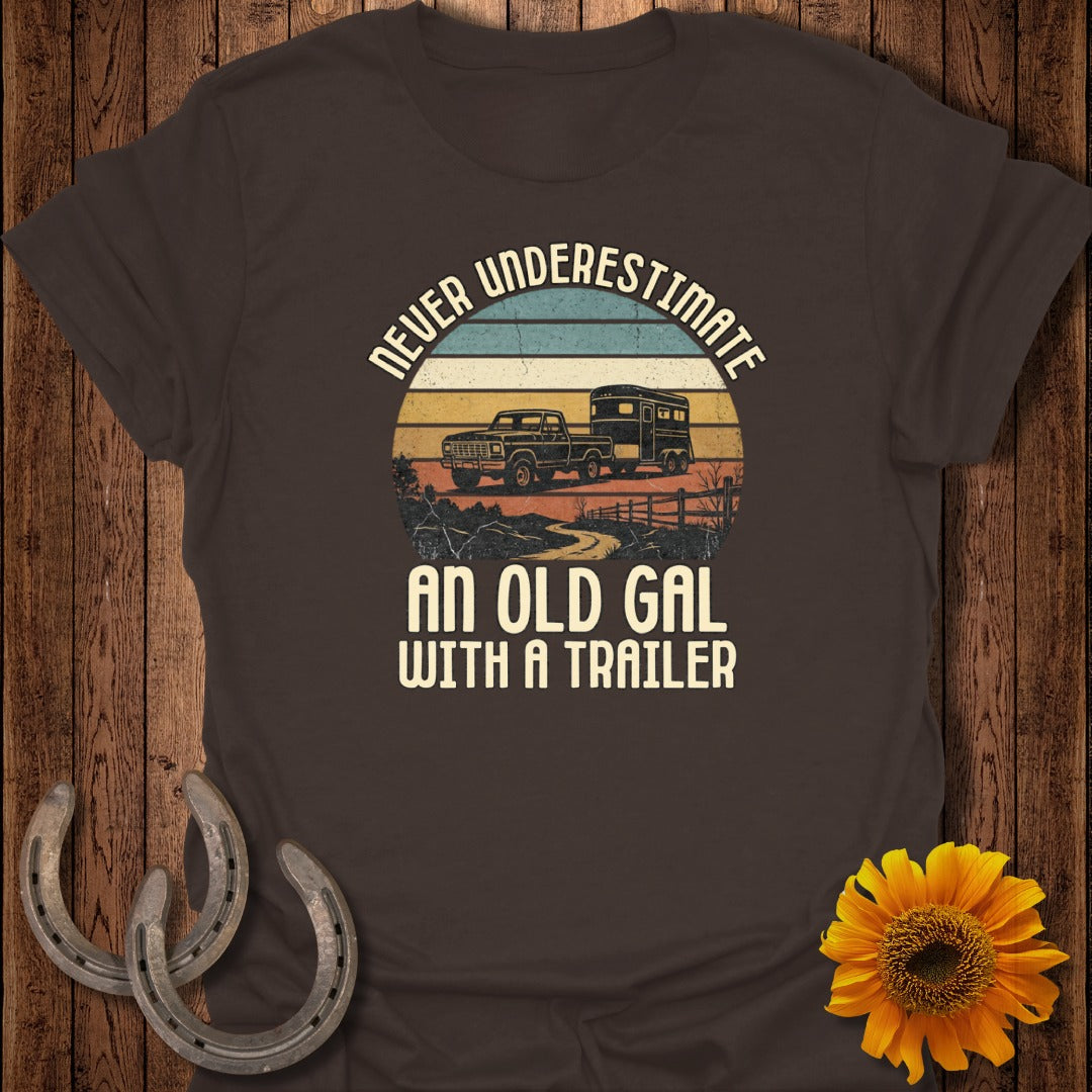 Brown t-shirt with "Never Underestimate An Old Gal With A Trailer" and truck with trailer graphic.