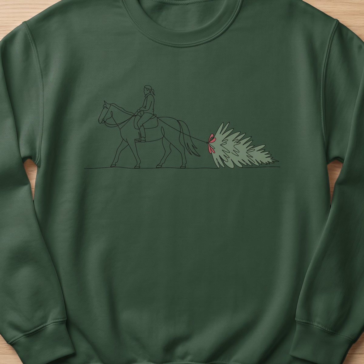 Dark green sweatshirt with a minimalist line drawing of a rider and horse pulling a Christmas tree.