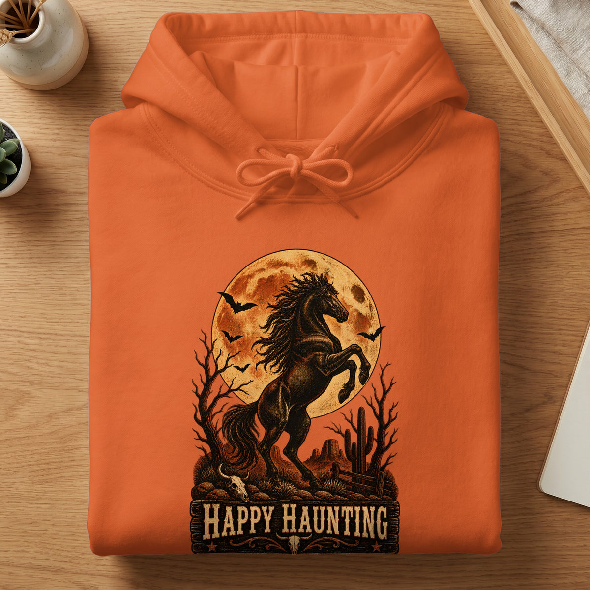 Orange hoodie with a black horse, moon, bats, and "Happy Haunting" text.