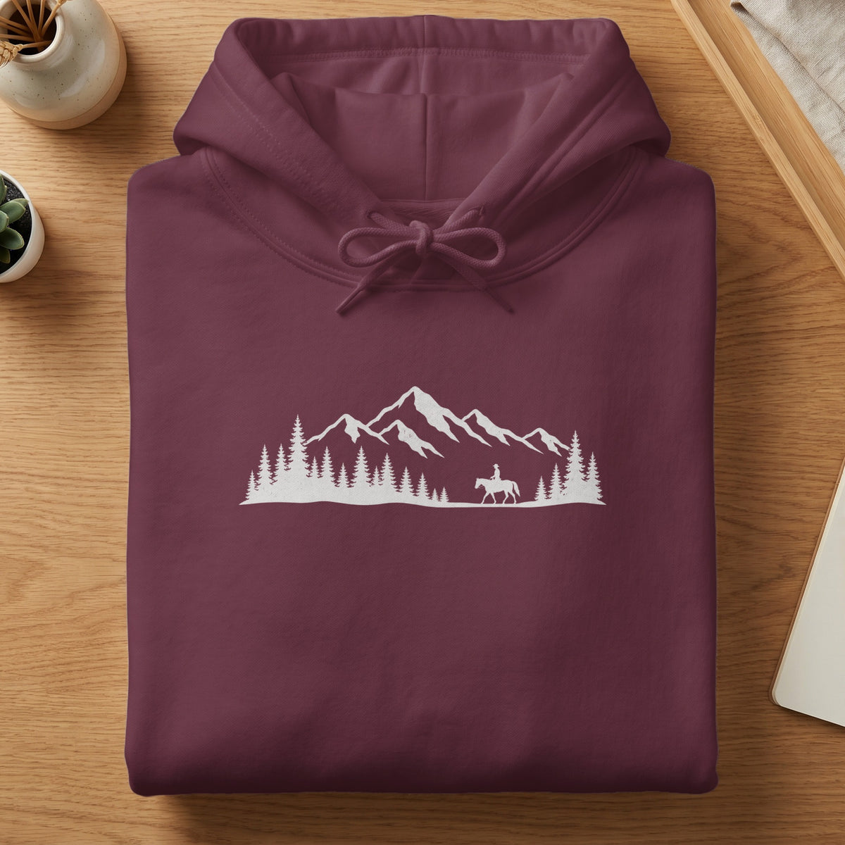 Maroon hoodie with white mountain landscape and horseback rider graphic.