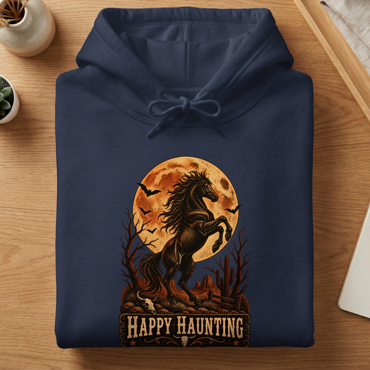 Dark blue hoodie with a "Happy Haunting" graphic featuring a horse, moon, and bats.