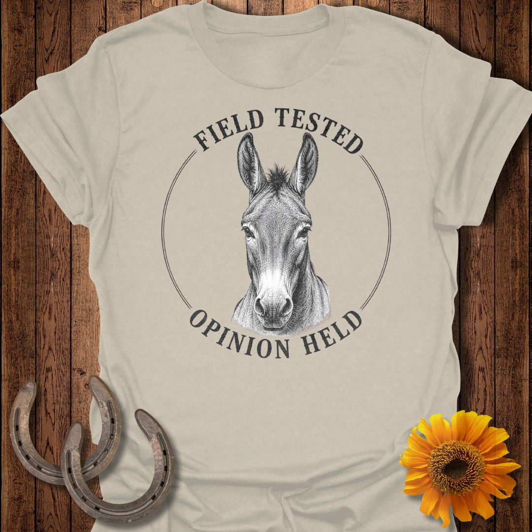 Donkey head drawing with text "FIELD TESTED OPINION HELD" on a beige t-shirt.