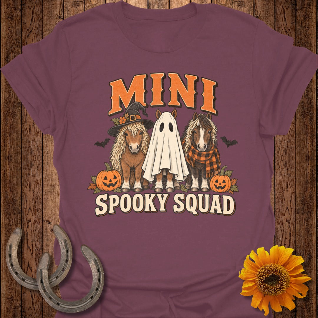 Three mini horses, one in a witch hat, one in a ghost costume, and one with a scarf, with pumpkins and text.