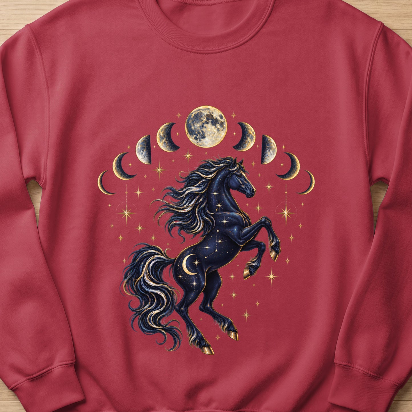 Dark horse with celestial moon phases and stars design on a maroon sweatshirt.