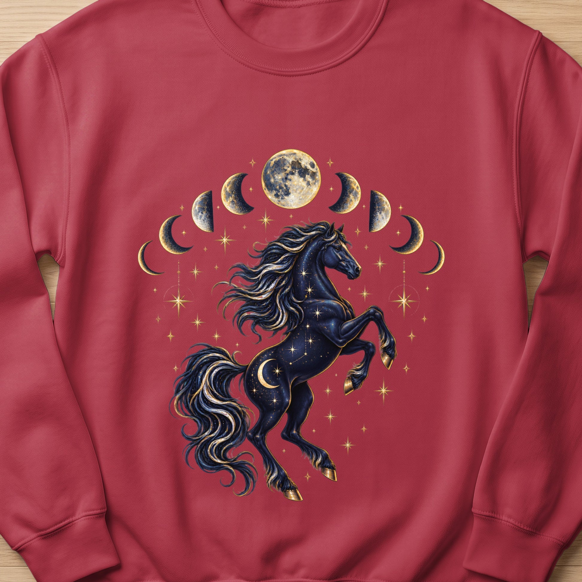 Dark horse with celestial moon phases and stars design on a maroon sweatshirt.